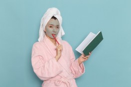 front-view-young-female-pink-bathrobe-after-shower-holding-copybook-blue-wall-beauty-water-cream-selfcare-shower-bathroom_140725-65386